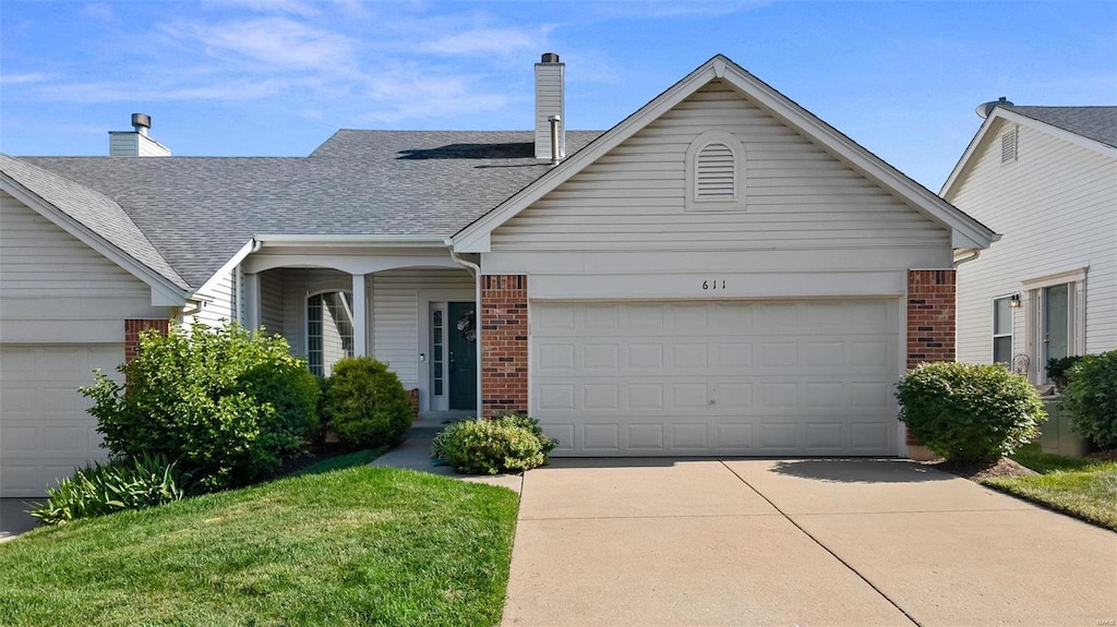 single story home featuring a front lawn and a garage