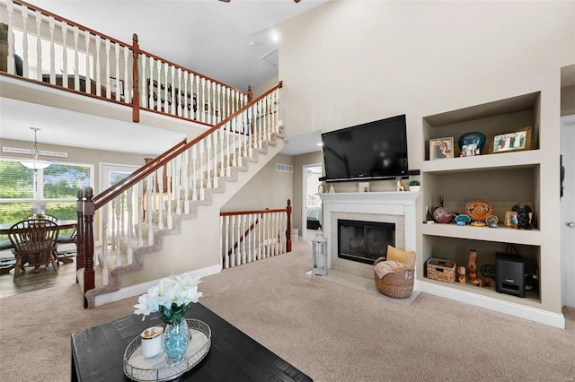 carpeted living room featuring a towering ceiling