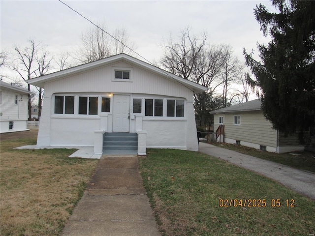 bungalow-style house featuring a garage and a front yard