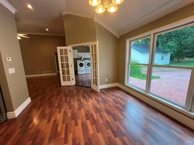 interior space with french doors, an inviting chandelier, crown molding, vaulted ceiling, and washing machine and dryer