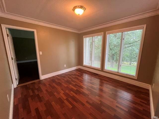 spare room with ornamental molding and dark wood-type flooring