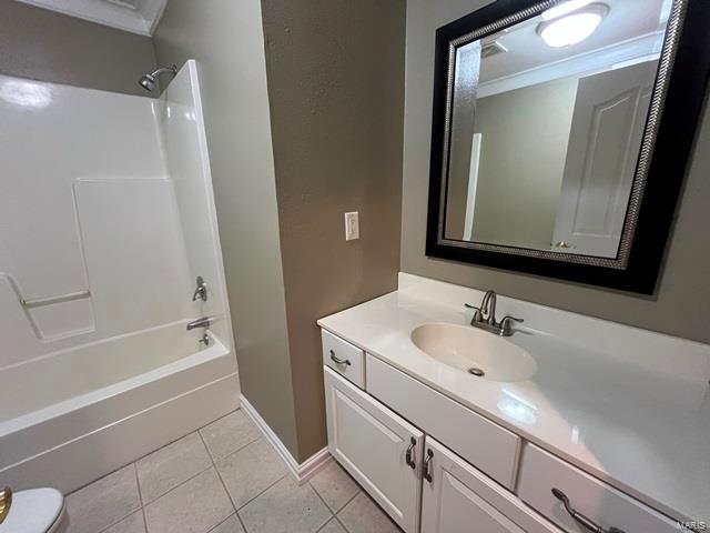 full bathroom featuring tile patterned floors, ornamental molding,  shower combination, and vanity