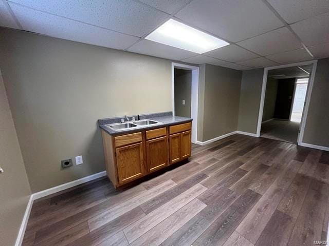 interior space featuring a paneled ceiling, dark hardwood / wood-style flooring, and sink