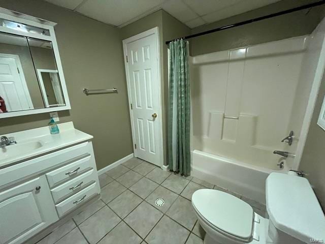 full bathroom with a paneled ceiling, shower / bath combination with curtain, vanity, toilet, and tile patterned floors