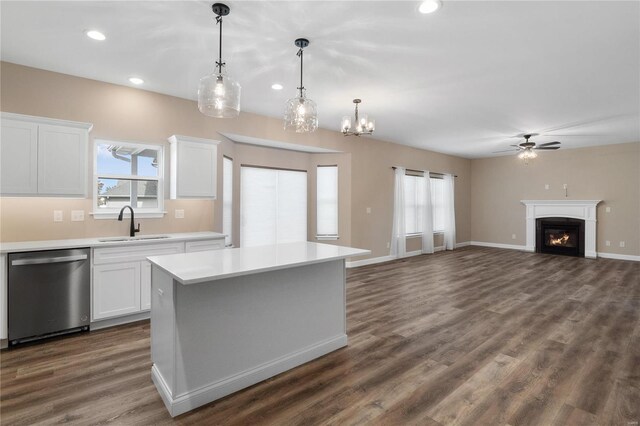 kitchen with ceiling fan with notable chandelier, dishwasher, a kitchen island, white cabinetry, and hanging light fixtures