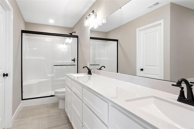 bathroom with toilet, walk in shower, and vanity