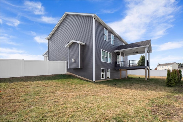 back of property featuring ceiling fan and a lawn