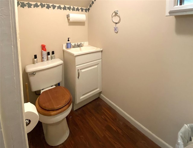 bathroom featuring toilet, vanity, and hardwood / wood-style flooring