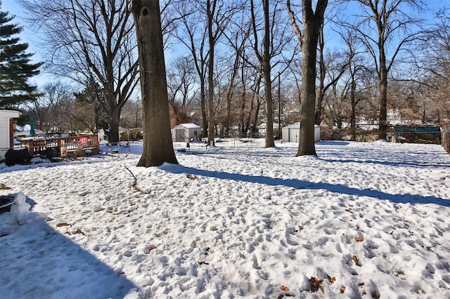 yard layered in snow with a storage shed