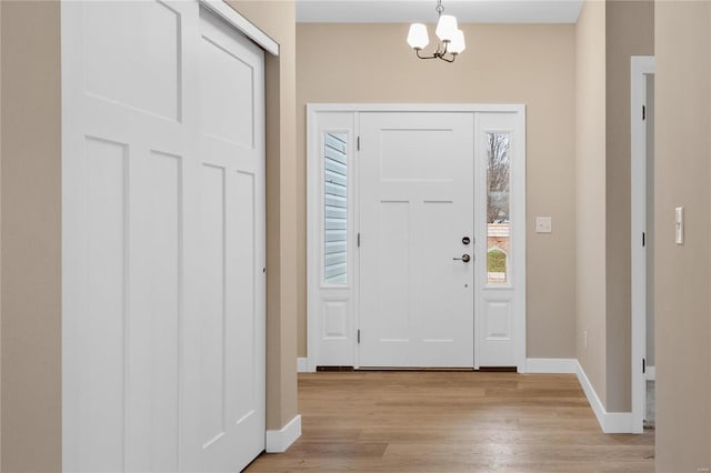 foyer entrance featuring light wood-type flooring and an inviting chandelier