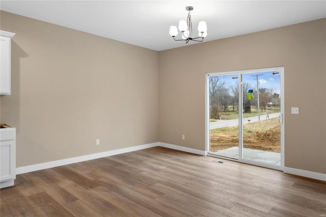 unfurnished dining area with light wood-type flooring and a chandelier