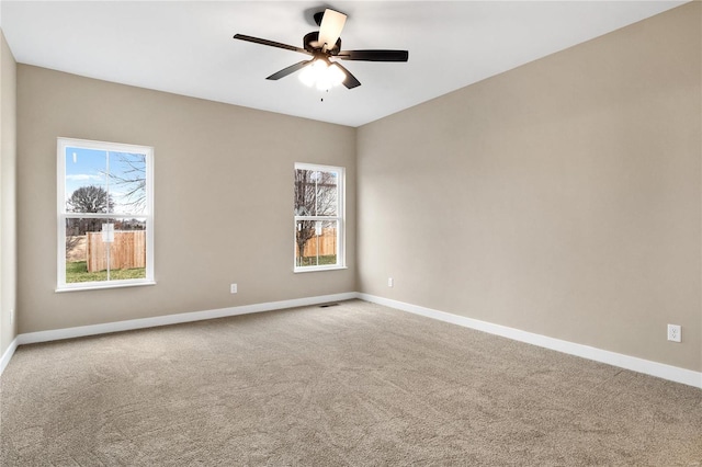 spare room featuring carpet floors, ceiling fan, and plenty of natural light