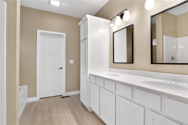 bathroom featuring hardwood / wood-style flooring, vanity, and separate shower and tub