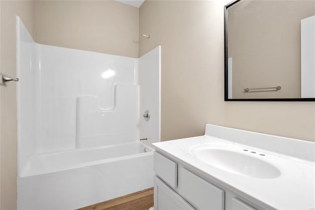 bathroom with hardwood / wood-style floors, shower / bathing tub combination, and vanity