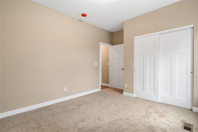 unfurnished bedroom with a closet and carpet flooring