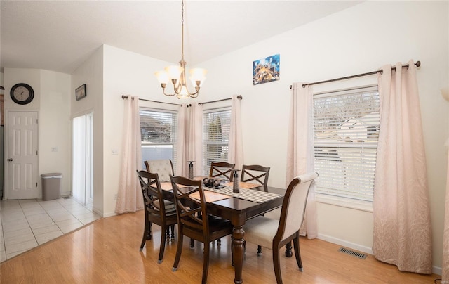 dining room featuring light wood-type flooring and a chandelier