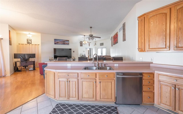 kitchen featuring light tile patterned floors, stainless steel dishwasher, sink, kitchen peninsula, and ceiling fan