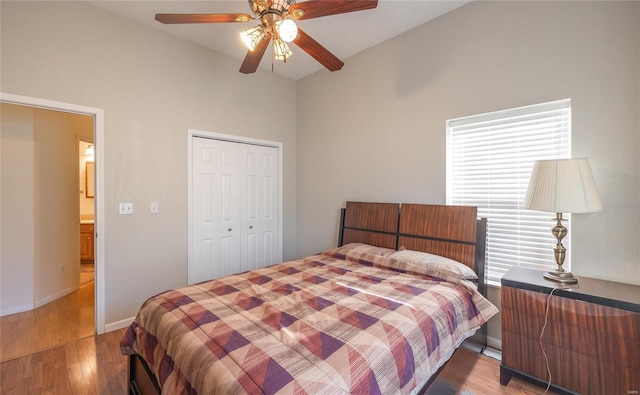 bedroom featuring lofted ceiling, hardwood / wood-style flooring, a closet, and ceiling fan