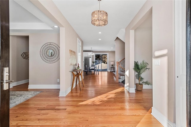 entryway with light hardwood / wood-style floors and a chandelier