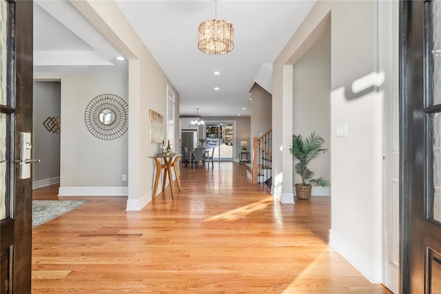 foyer entrance featuring a chandelier and light hardwood / wood-style floors