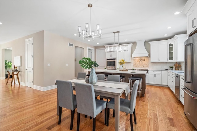 dining room featuring light hardwood / wood-style flooring and a notable chandelier