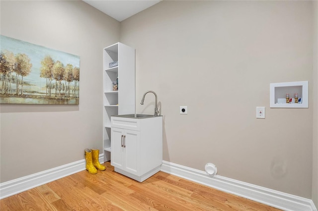 washroom featuring hookup for a washing machine, sink, light hardwood / wood-style flooring, and electric dryer hookup