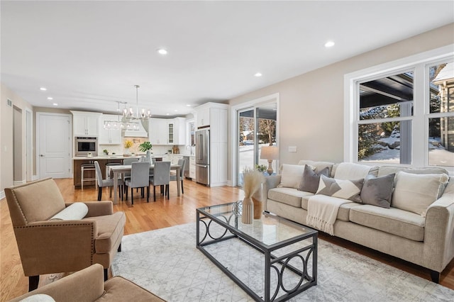 living room with an inviting chandelier and light hardwood / wood-style flooring