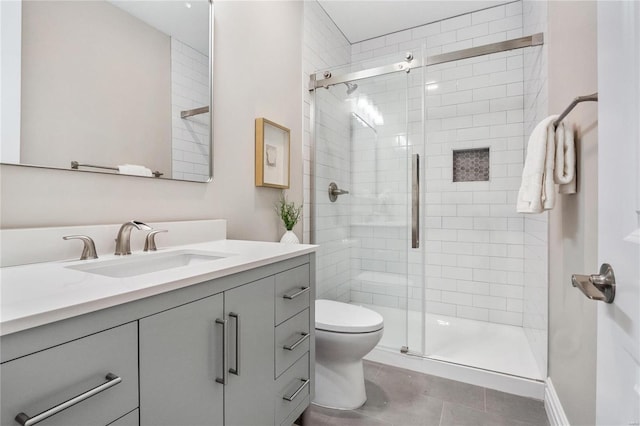 bathroom with toilet, a shower with shower door, and vanity