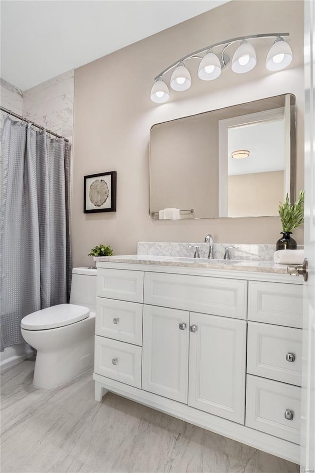 bathroom with toilet, vanity, and a shower with curtain