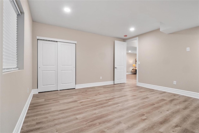 unfurnished bedroom featuring light wood-type flooring and a closet