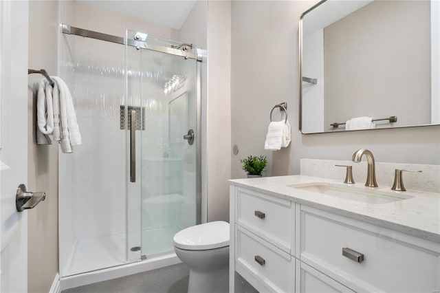 bathroom featuring toilet, an enclosed shower, and vanity