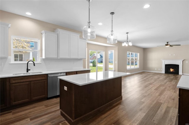 kitchen with hardwood / wood-style flooring, tasteful backsplash, hanging light fixtures, stainless steel dishwasher, and sink