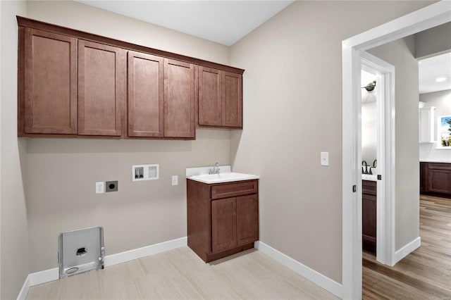 clothes washing area featuring hookup for an electric dryer, hookup for a gas dryer, washer hookup, cabinets, and sink