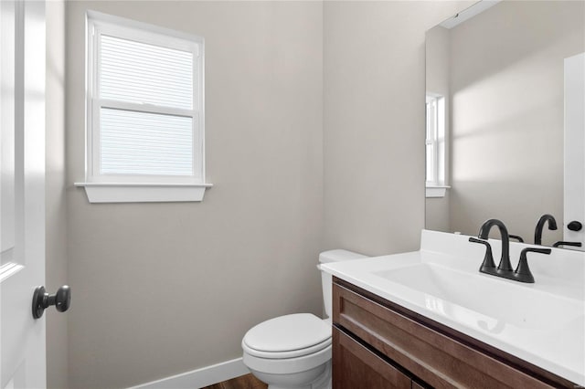 bathroom with toilet, wood-type flooring, and vanity