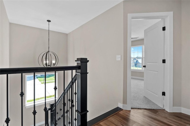 hall with dark hardwood / wood-style flooring and an inviting chandelier