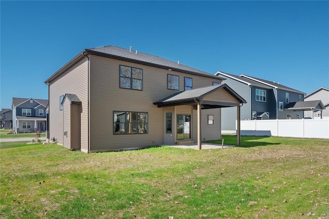 back of house featuring a lawn and a patio area