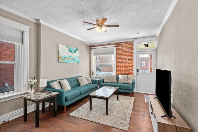 living room featuring ceiling fan, dark wood-type flooring, a textured ceiling, and ornamental molding