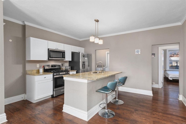 kitchen featuring stainless steel appliances, pendant lighting, white cabinetry, and light stone countertops