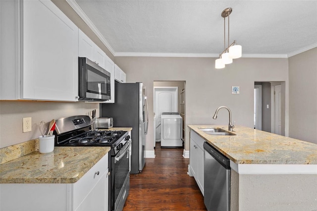 kitchen with washer / dryer, white cabinetry, appliances with stainless steel finishes, decorative light fixtures, and sink