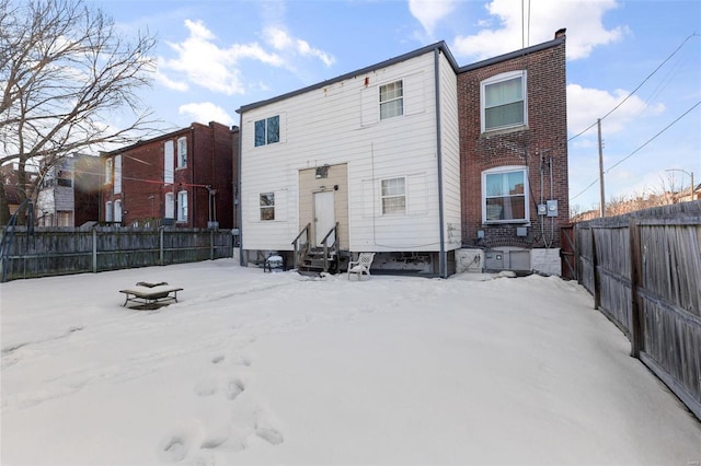 view of snow covered rear of property