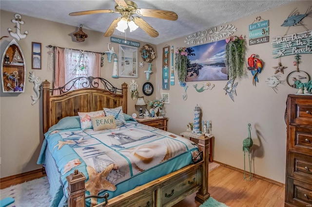 bedroom with ceiling fan, a textured ceiling, and light hardwood / wood-style flooring