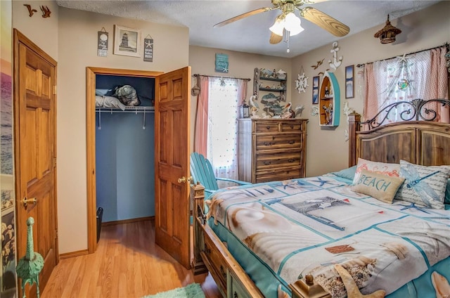 bedroom with ceiling fan, a closet, and light hardwood / wood-style flooring