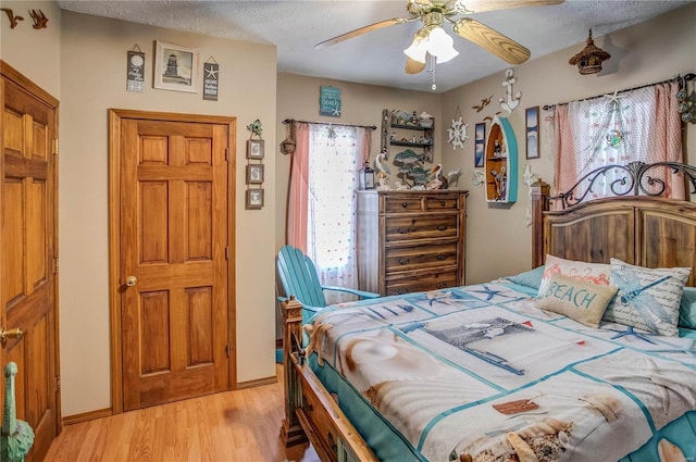 bedroom featuring ceiling fan, a textured ceiling, and light hardwood / wood-style floors