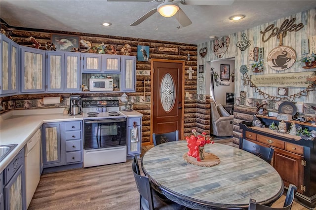 kitchen with white appliances, rustic walls, and a textured ceiling