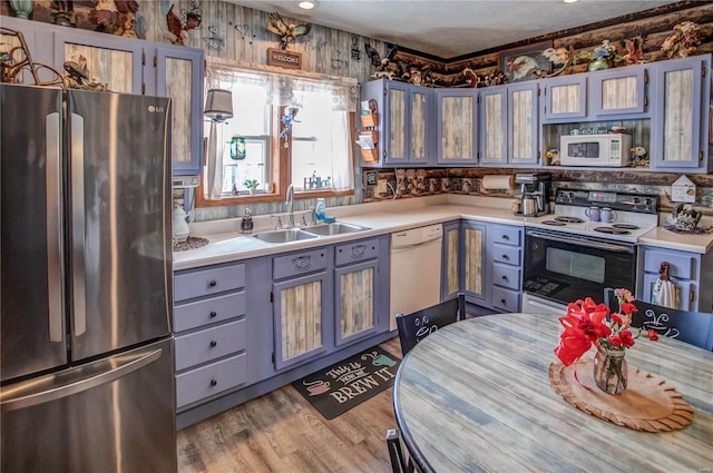 kitchen featuring light wood-type flooring, sink, and white appliances