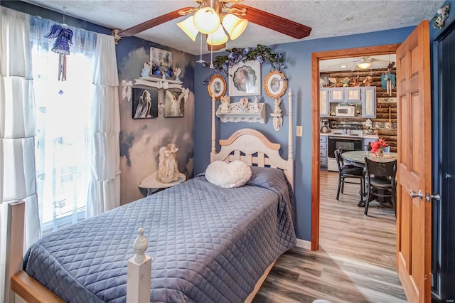 bedroom featuring ceiling fan, a textured ceiling, and hardwood / wood-style flooring