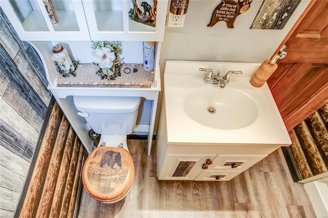 bathroom featuring hardwood / wood-style flooring, toilet, and vanity