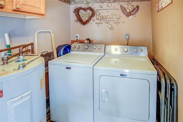 clothes washing area with cabinets, electric water heater, and independent washer and dryer