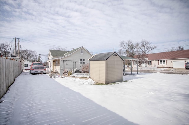 snow covered property with a shed