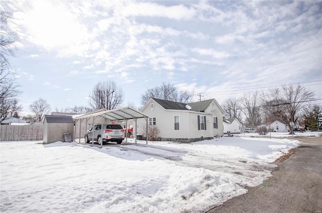 view of front of home with a carport and a storage shed